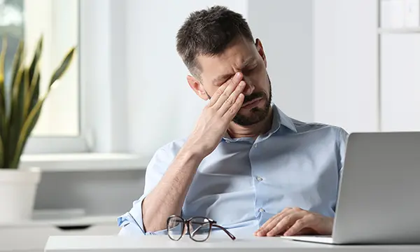 Mann reibt sich seine trockenen Augen